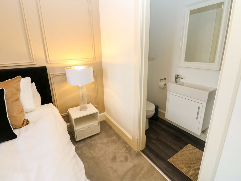 A bedroom with a bed and an adjoining bathroom at Flaxstead Grange in Newbottle