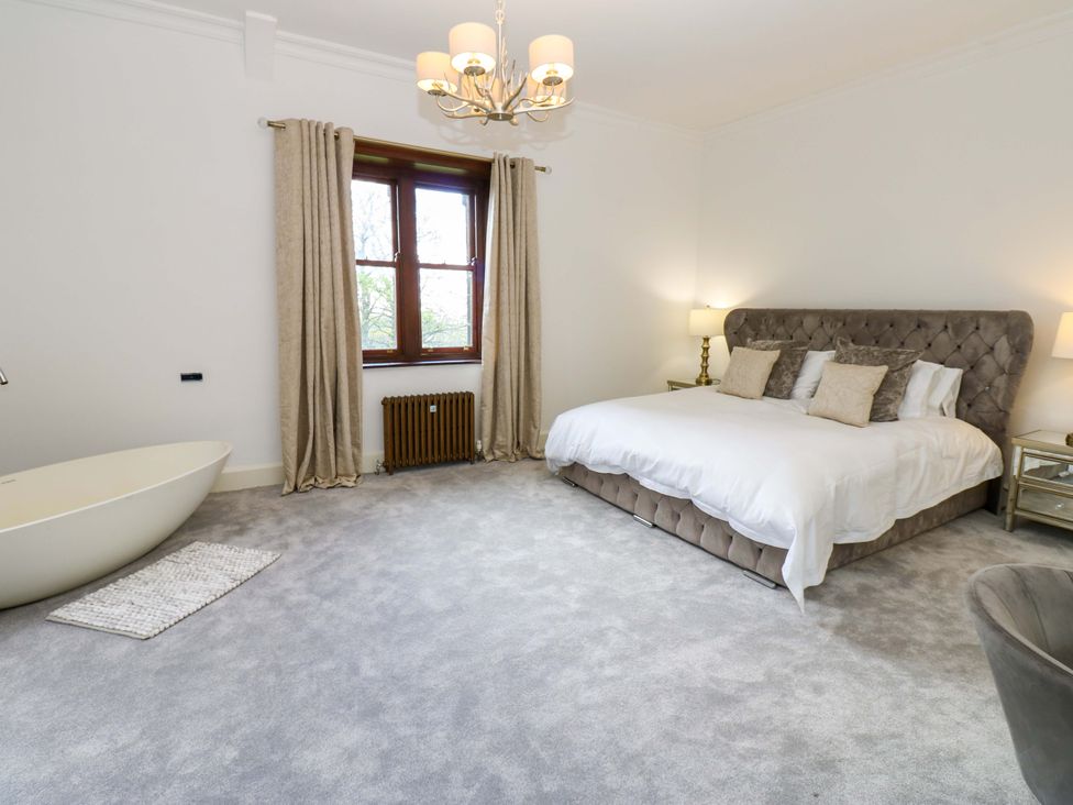 A bedroom with a bed and bathtub at Flaxstead Grange in Newbottle