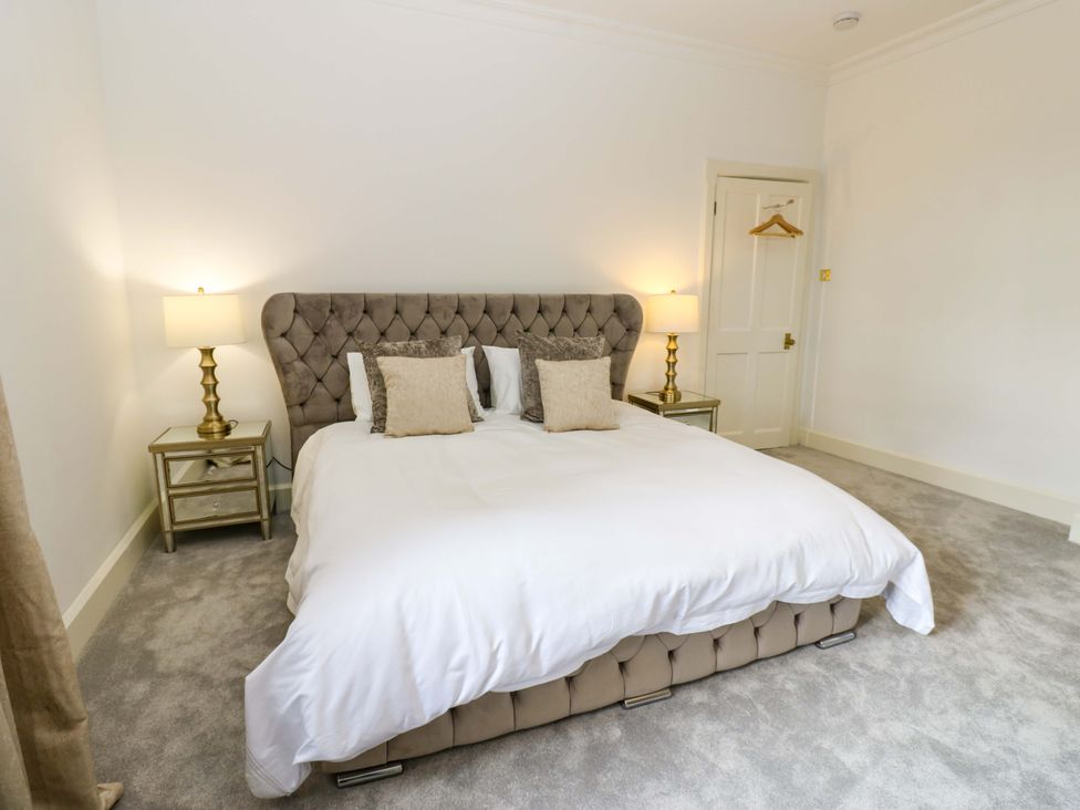 A bedroom with a bed, bedside tables and lamps at Flaxstead Grange in Newbottle