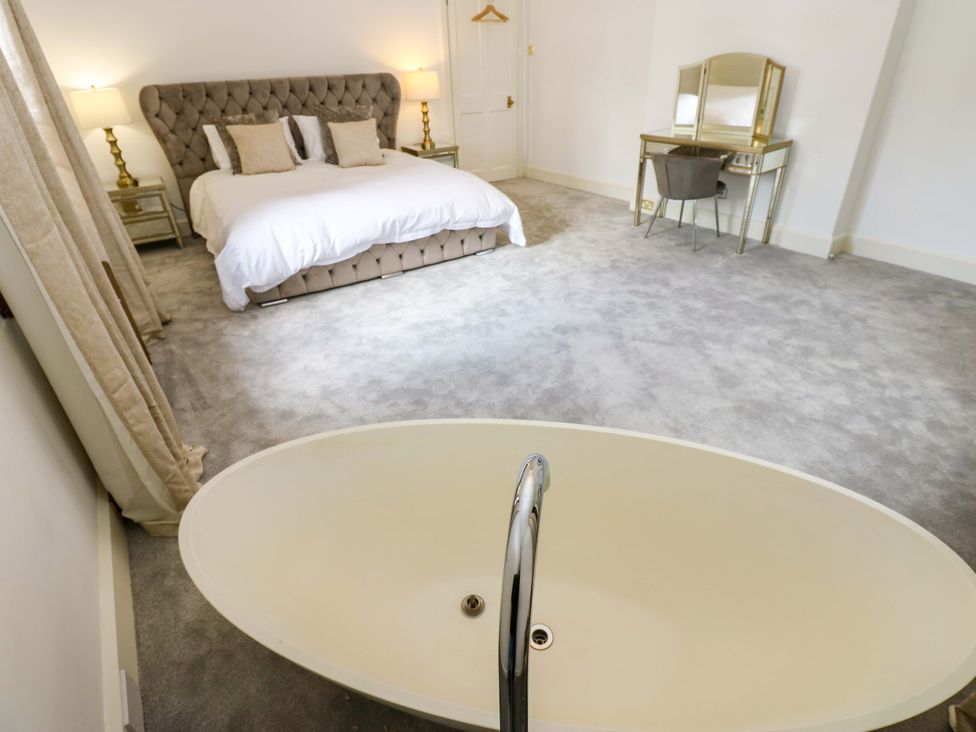A bedroom with a bed and a bathtub at Flaxstead Grange in Newbottle