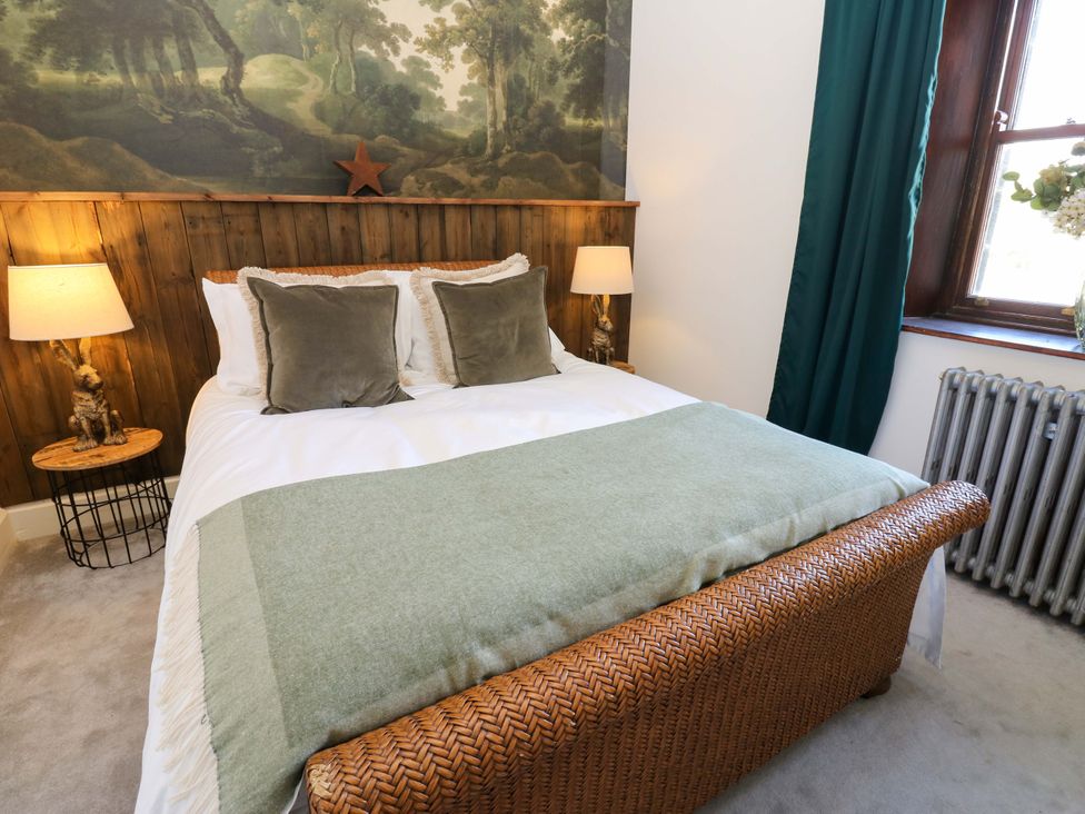 A bedroom with a bed, bedside table, and wall art at Flaxstead Grange in Newbottle