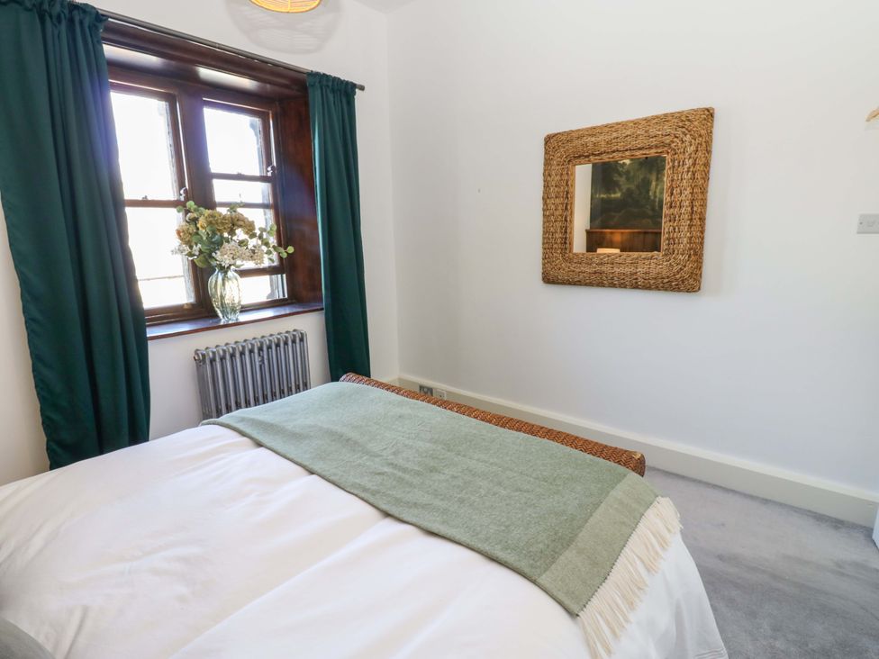 A bedroom with a bed and a mirror at Flaxstead Grange in Newbottle