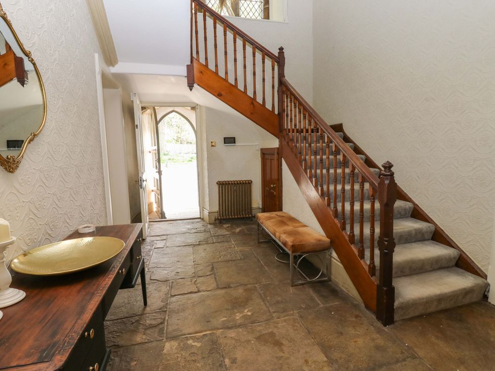 A hallway with a staircase and a table at Flaxstead Grange in Newbottle
