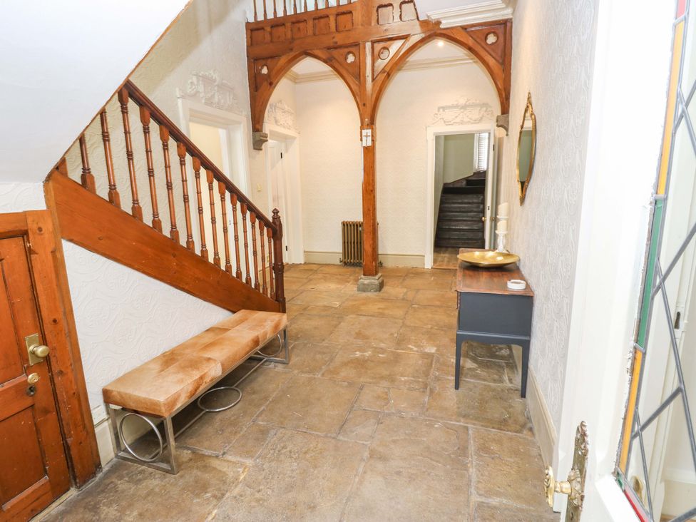 A hallway with a staircase and a bench at Flaxstead Grange in Newbottle