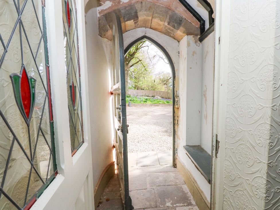 An entrance hall with a door and stained glass at Flaxstead Grange in Newbottle