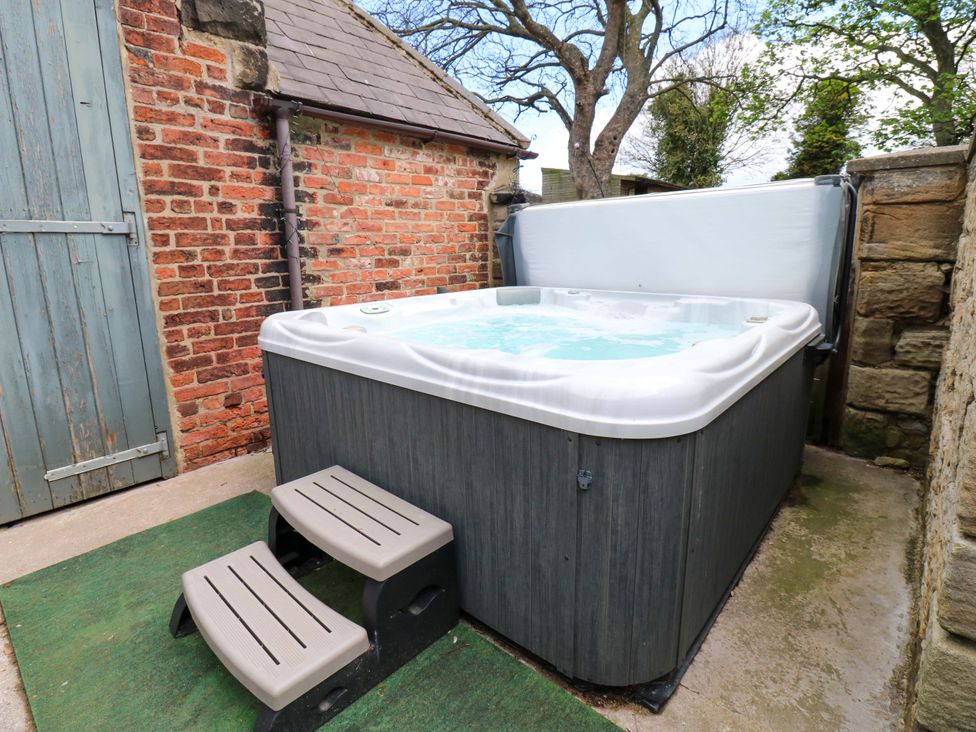 An outdoor bath area with a hot tub and steps at Flaxstead Grange in Newbottle