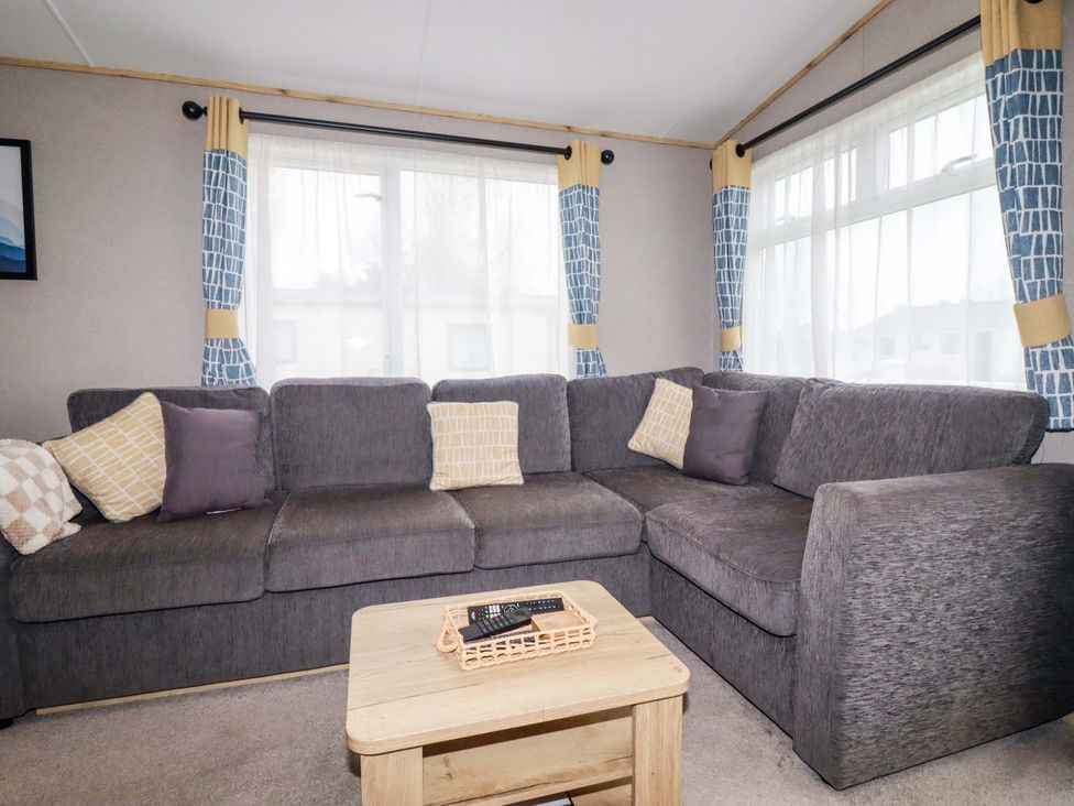 A living room with a grey sofa and a coffee table at Derwent L4 in Par