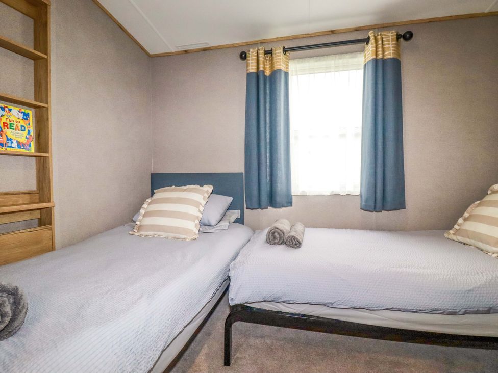 A bedroom with two beds and a bookshelf at Derwent L4, Par