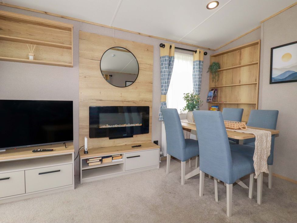 A living room with a television and dining table at Derwent L4 in Par