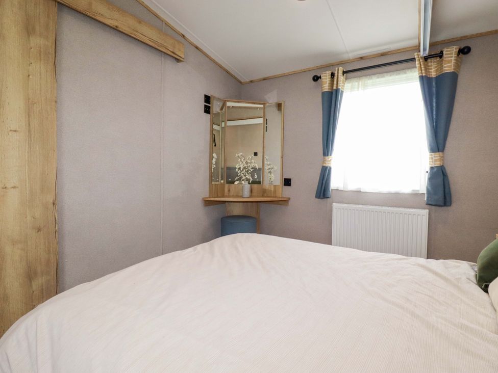 A bedroom with a bed and a vanity mirror at Derwent L4 in Par