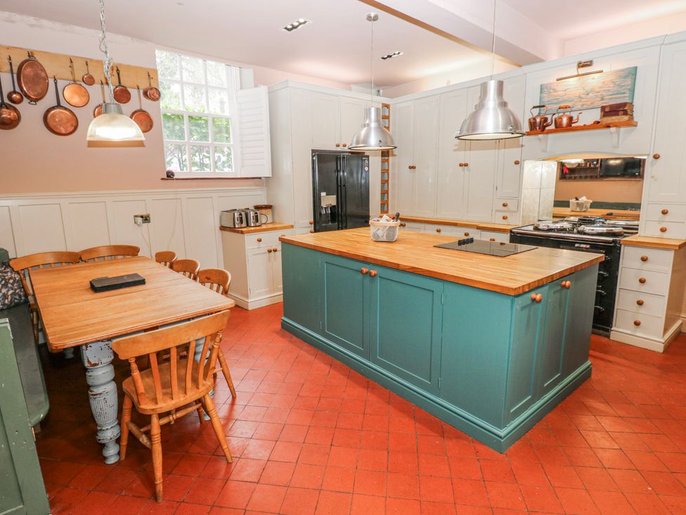 A kitchen with a large island and dining table at The Old Vicarage in Carmarthen