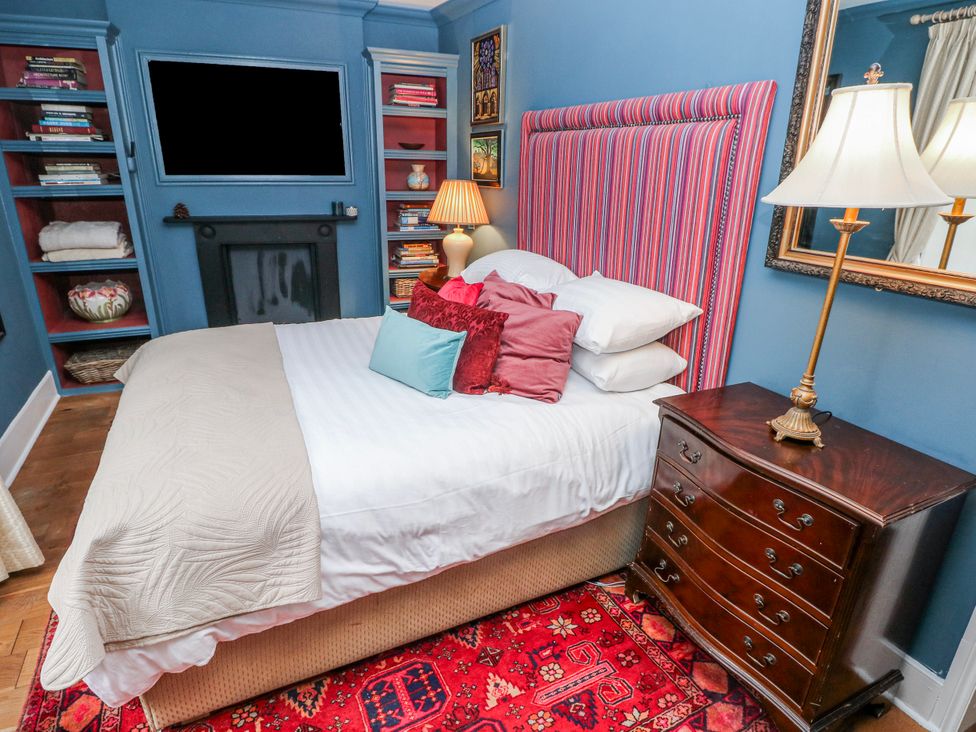 A bedroom with a bed and bookshelf at The Old Vicarage in Carmarthen