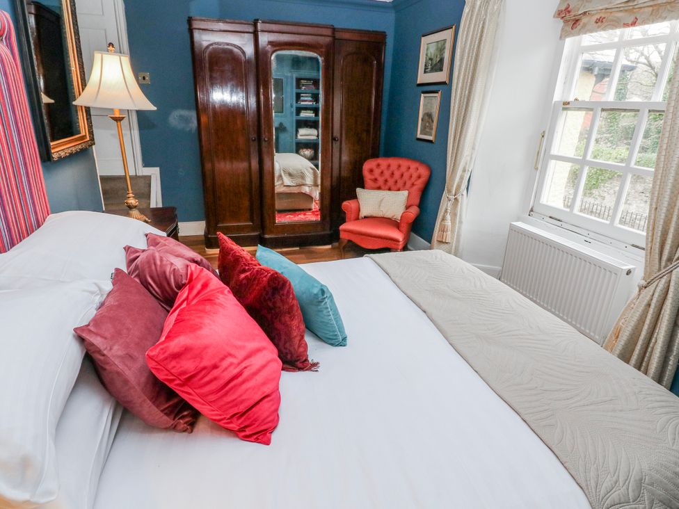 A bedroom with a bed and wardrobe at The Old Vicarage in Carmarthen