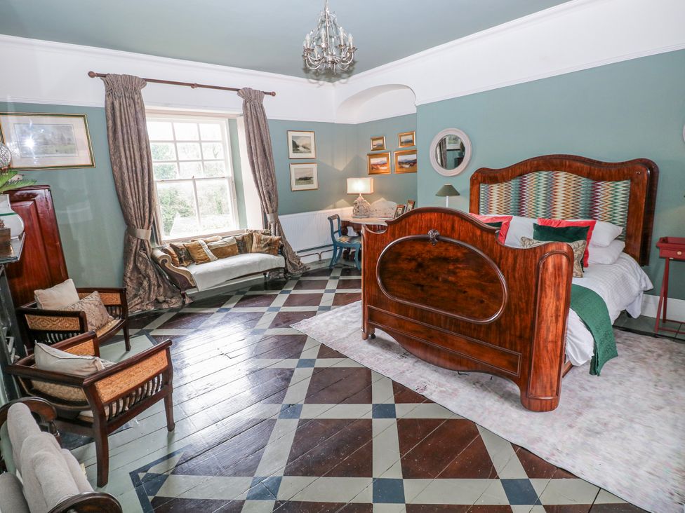 A bedroom with a bed and seating area at The Old Vicarage in Carmarthen
