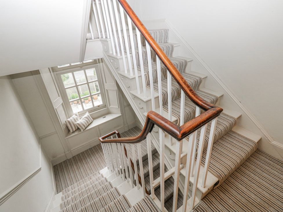 A staircase with carpet and a window at The Old Vicarage in Carmarthen