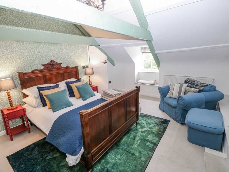 A bedroom with a bed and sofa at The Old Vicarage in Carmarthen
