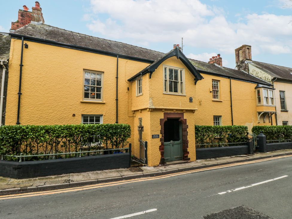 A house with yellow exterior and a hedge in front at The Old Vicarage in Carmarthen