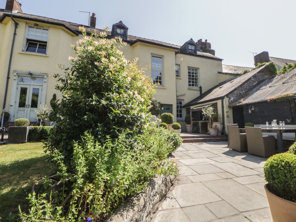 A garden with plants and a house at The Old Vicarage in Laugharne