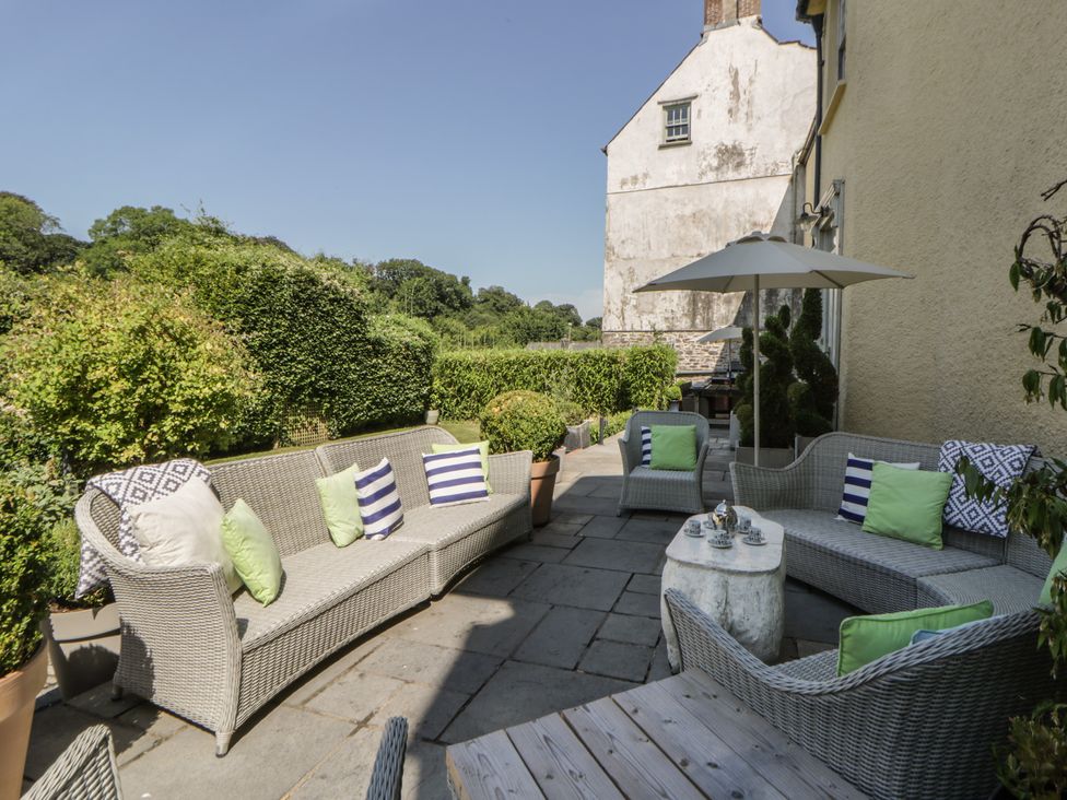 A patio area with seating and an umbrella at The Old Vicarage in Laugharne