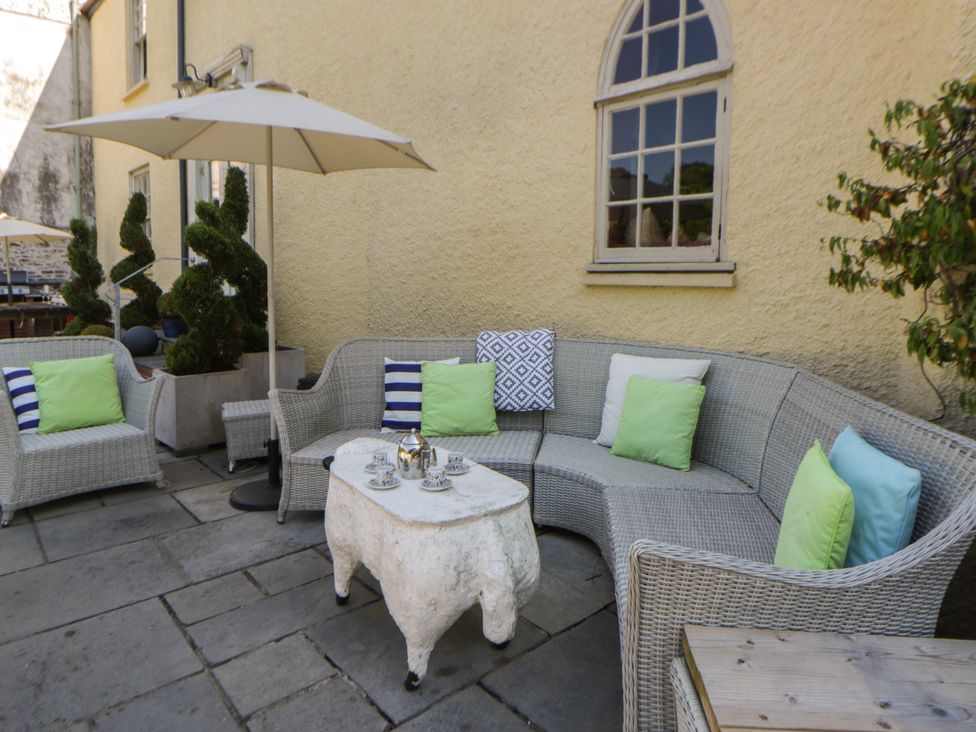 An outdoor seating area with a sofa and table at The Old Vicarage in Laugharne