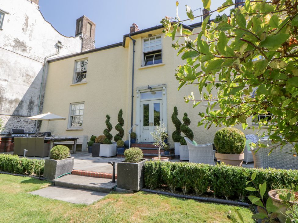 A garden with a house and patio furniture at The Old Vicarage in Laugharne