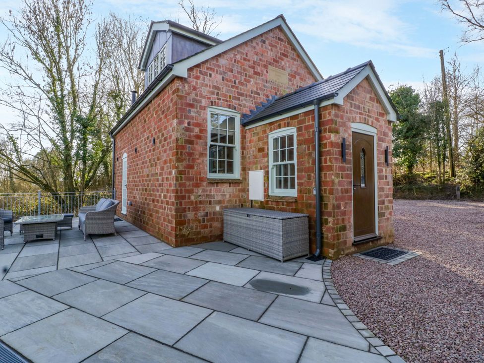 An outdoor area with a brick building and seating arrangements at Broadmoor Chapel Hereford