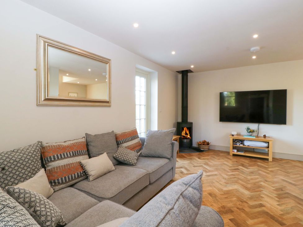 A living room with a sofa, television, and fireplace at Broadmoor Chapel in Hereford