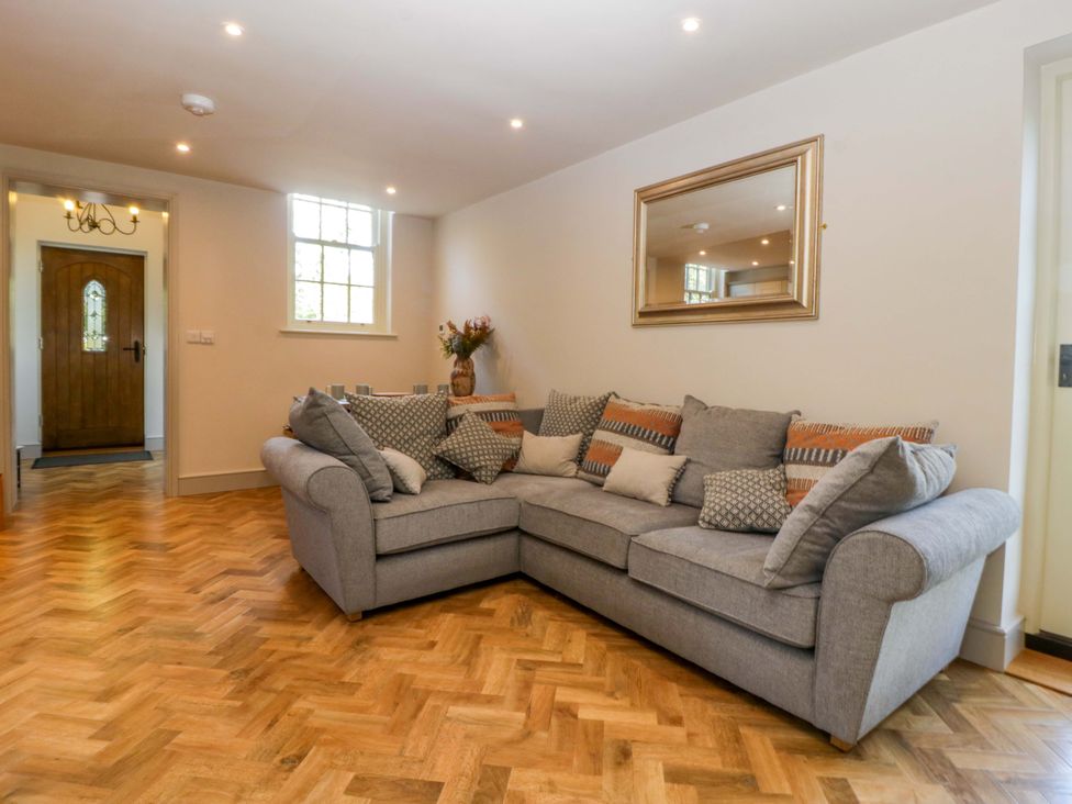 A living room with a sofa and mirror at Broadmoor Chapel Hereford