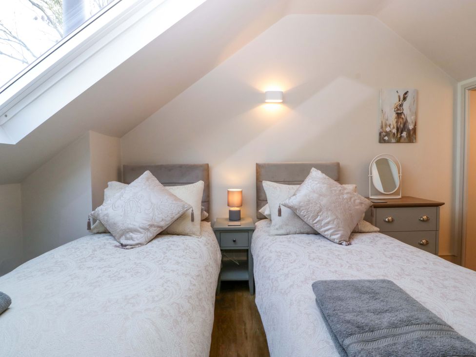 A bedroom with two beds and a bedside table at Broadmoor Chapel in Hereford