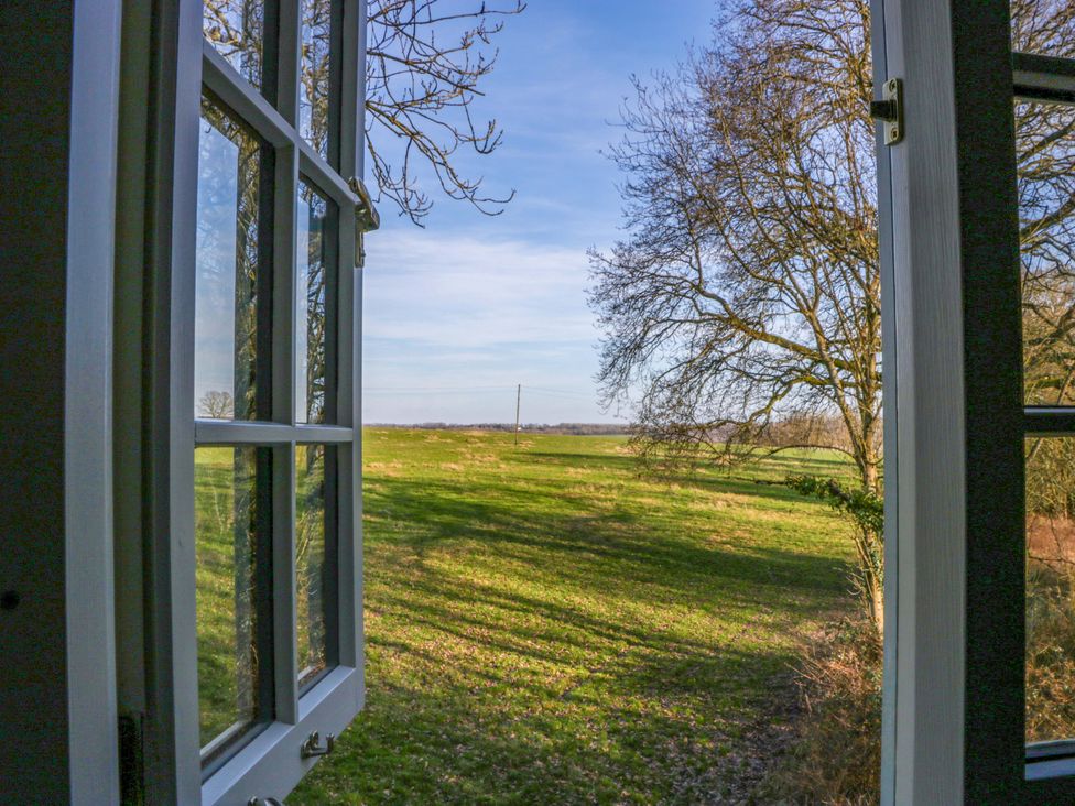 A view from a window showing grass and trees at Broadmoor Chapel in Hereford