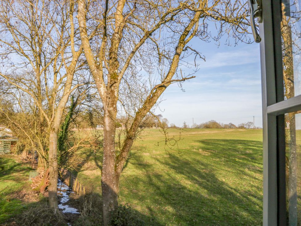 A view of trees and a field with a stream at Broadmoor Chapel in Hereford