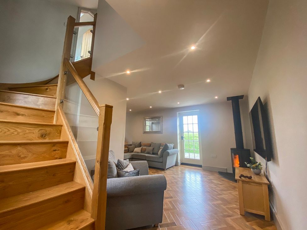 A living room with a staircase and sofa at Broadmoor Chapel in Hereford