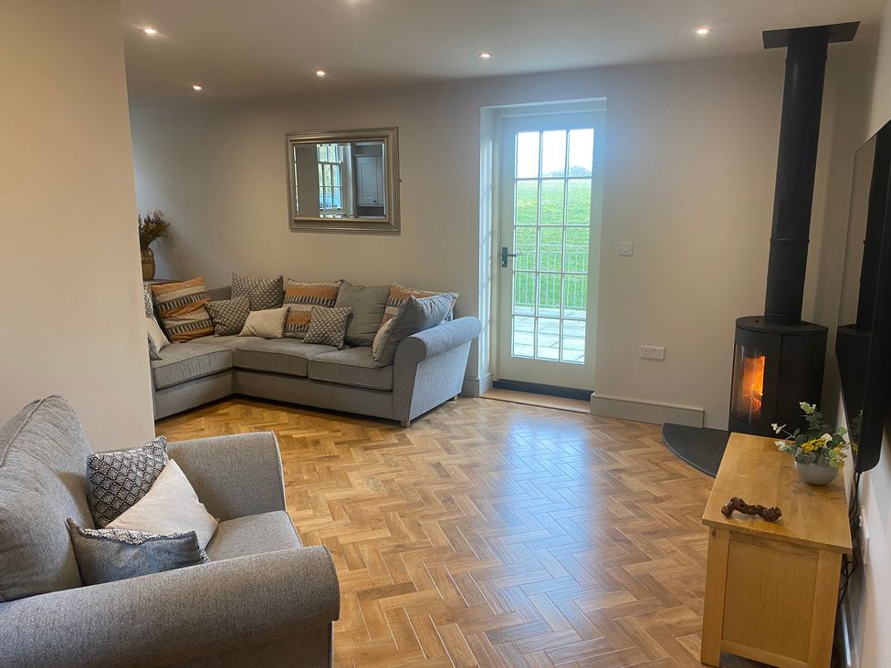 A living room with a sofa, fireplace, and table at Broadmoor Chapel in Hereford