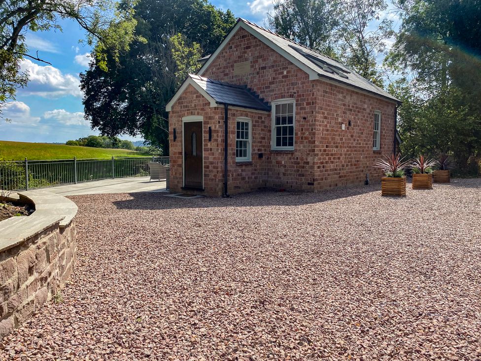A brick house with planters in an outdoor area at Broadmoor Chapel Hereford