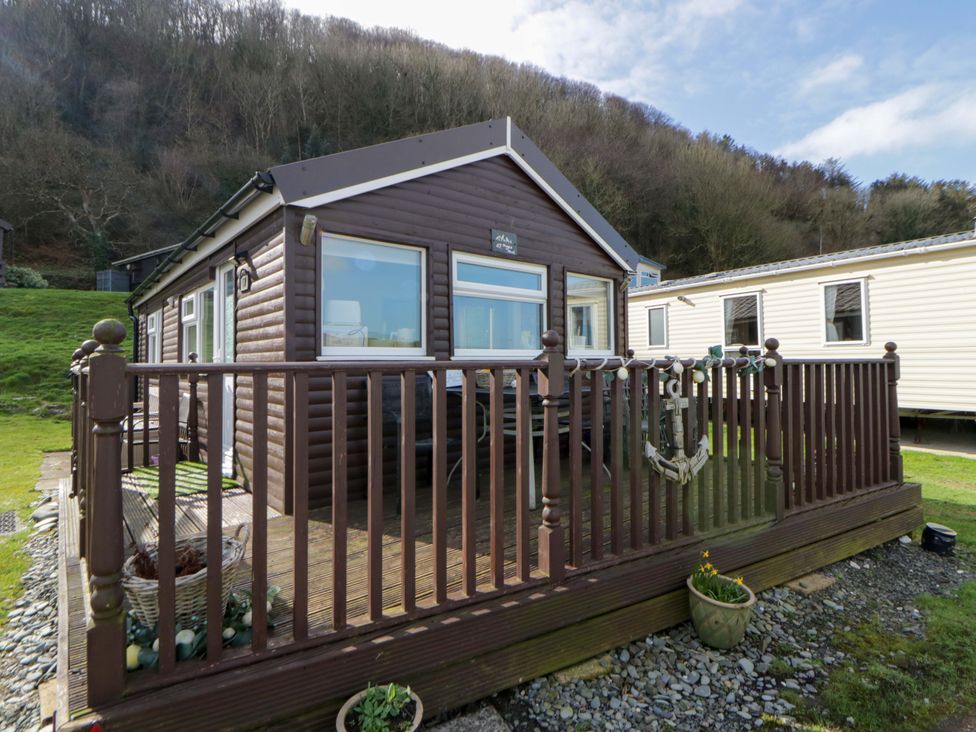 A house with a deck and seating area at The Cosy Den in Clarach near Aberystwyth