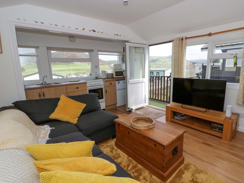 A living room with a sofa and television at The Cosy Den in Clarach near Aberystwyth