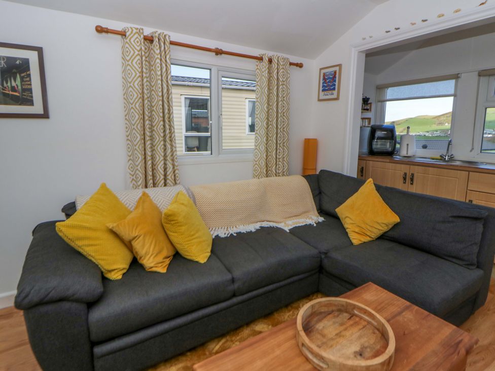 A living room with a sofa and cushions at The Cosy Den in Clarach near Aberystwyth