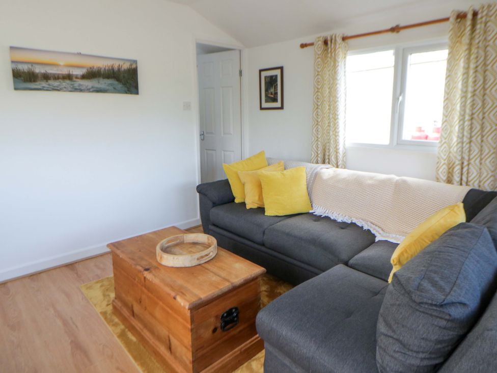 A living room with a sofa and coffee table at The Cosy Den in Clarach near Aberystwyth