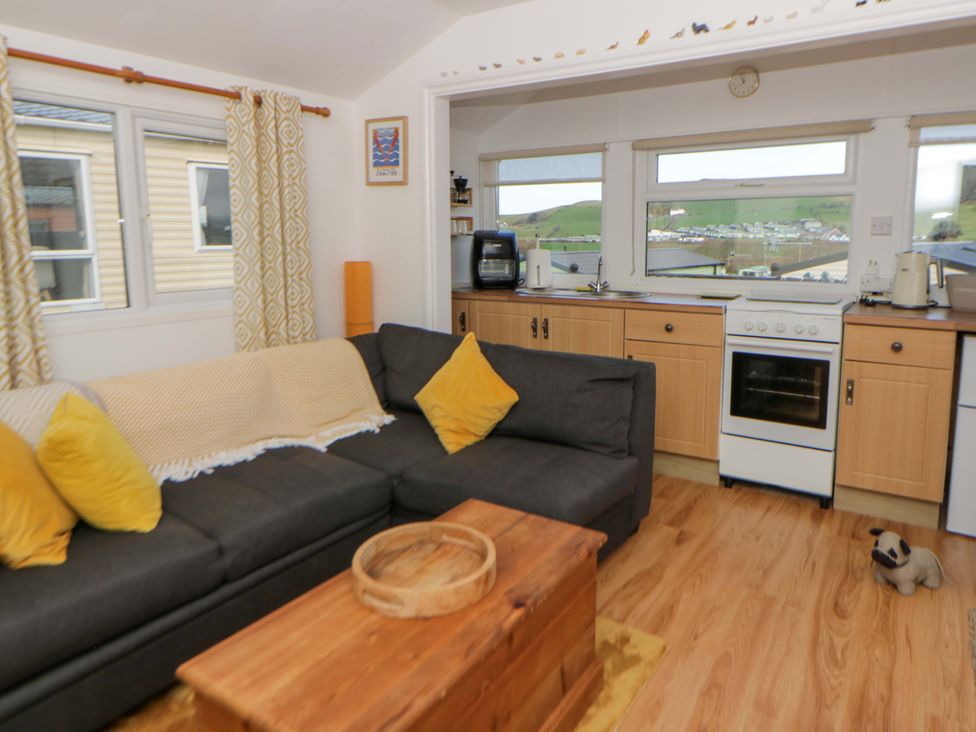A living room with a sofa and kitchen units at The Cosy Den in Clarach near Aberystwyth