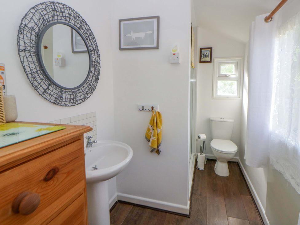A bathroom with a sink and toilet at The Cosy Den in Clarach near Aberystwyth