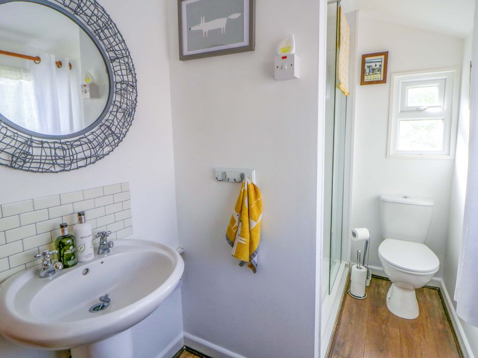 A bathroom with a wash basin and shower at The Cosy Den in Clarach near Aberystwyth