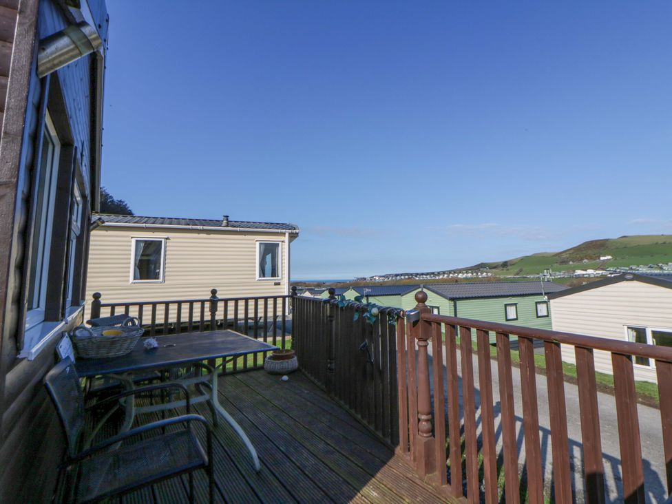 An outdoor deck with furniture and a view at The Cosy Den in Clarach near Aberystwyth