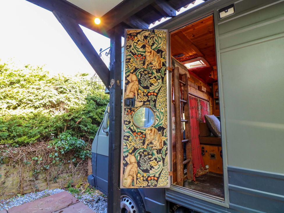 An entrance door and ladder in a mobile living space at Old Rosie in Grantham