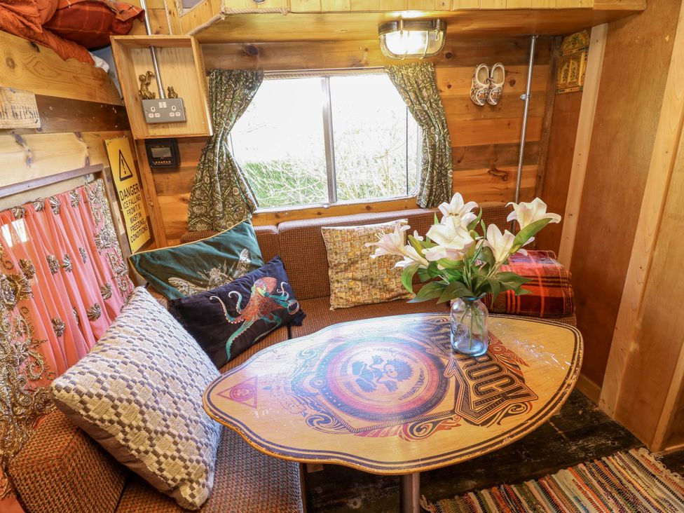 A snug with a couch and table decorated with flowers at Old Rosie Grantham