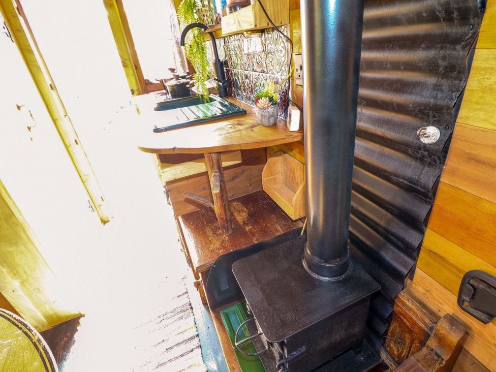 A kitchen with a wood stove and sink at Old Rosie in Grantham