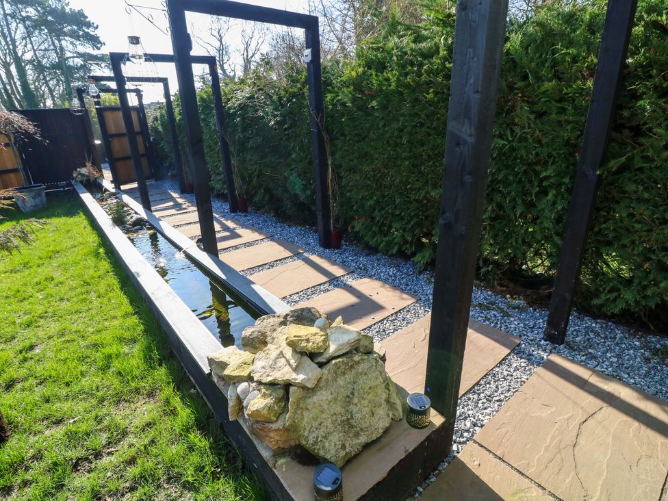 A garden with a pathway and water feature at Old Rosie in Grantham