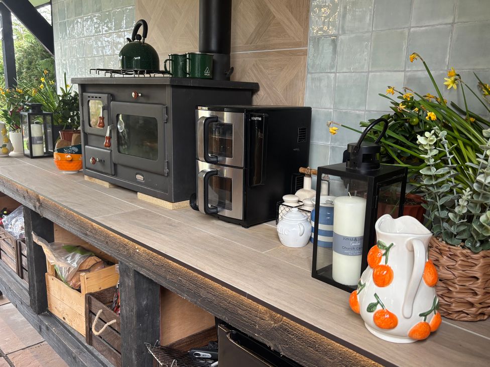 A kitchen with a stove, microwave, and plants at Old Rosie in North Witham near Colsterworth