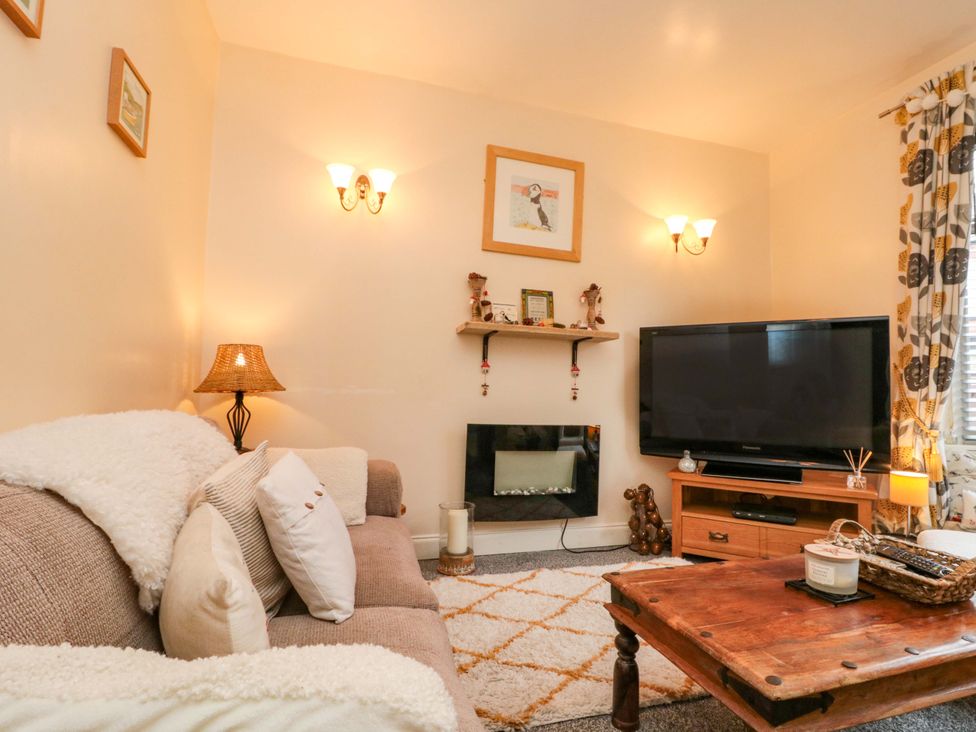 A living room with a sofa and television at 46 Nelson Street in Bridlington