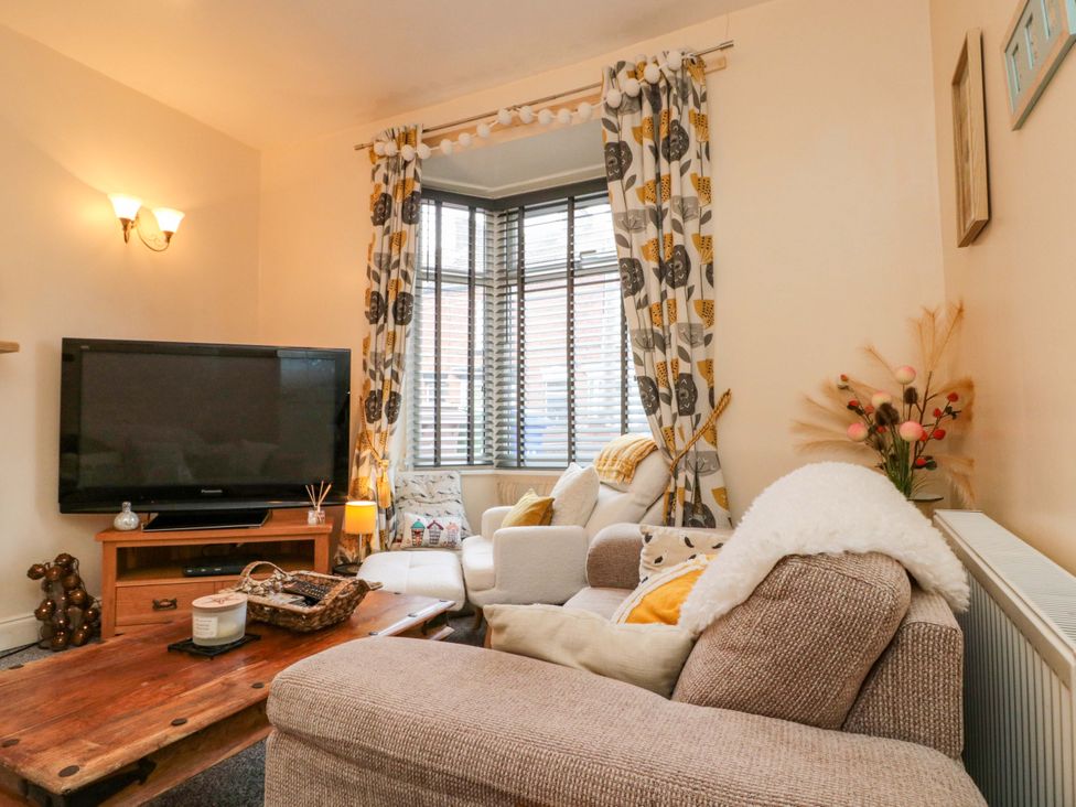 A living room with a television and sofa at 46 Nelson Street Bridlington