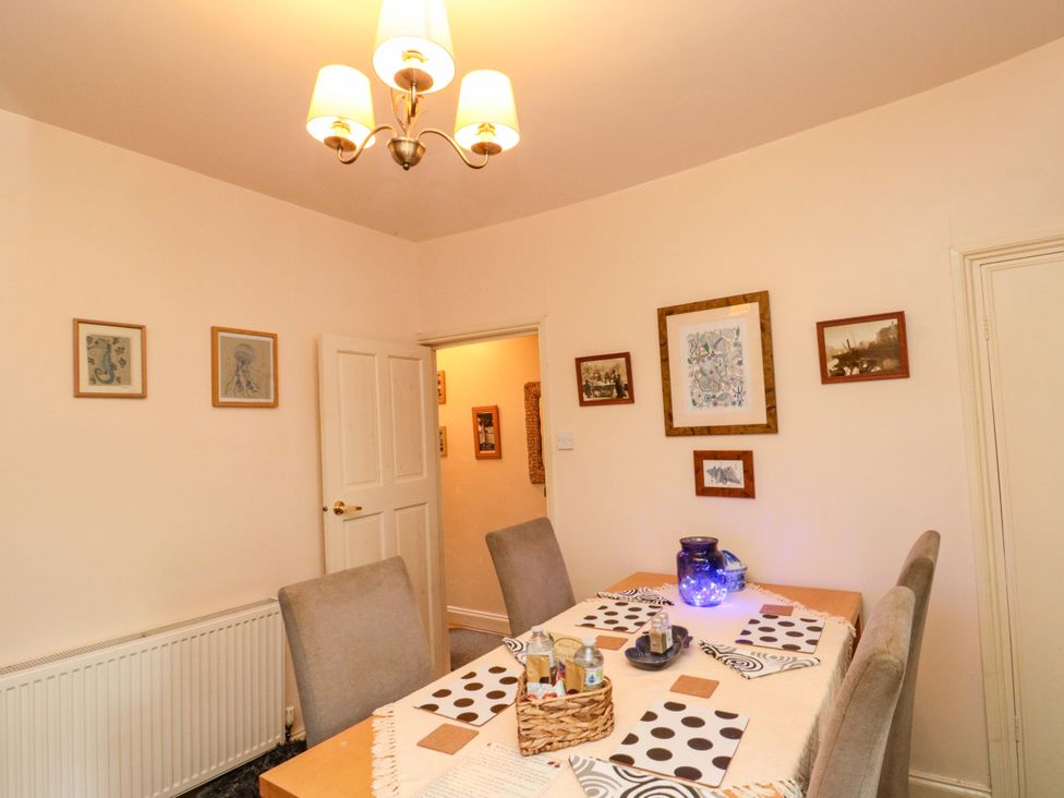 A dining room with a table set and wall art at 46 Nelson Street in Bridlington